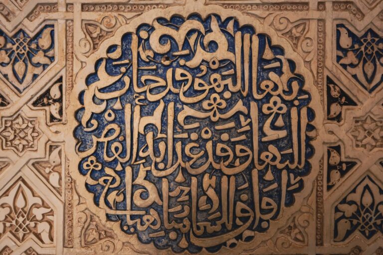 Intricate arabic calligraphy carved into a textured wall